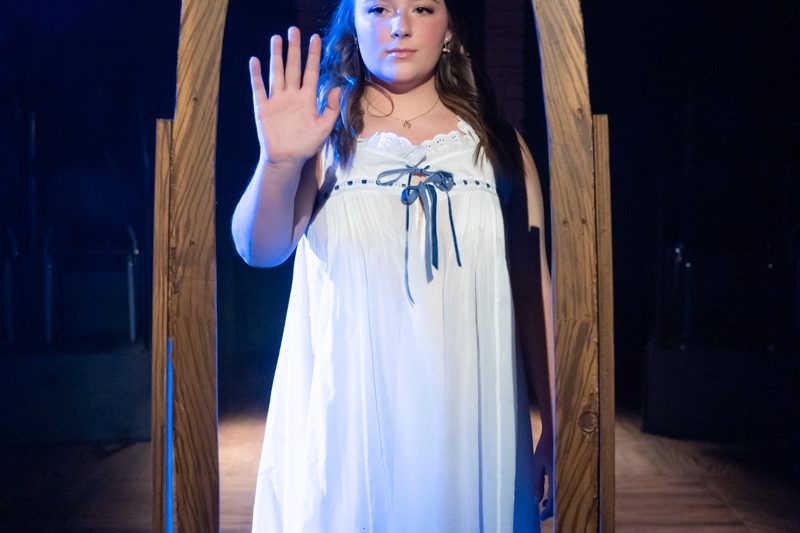 2022 Spring Awakening Promotional Photo Girl in white nightgown looking in mirror.